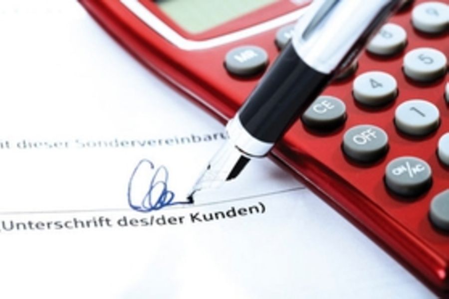 Vertragsunterschrift mit Füllfederhalter und Taschenrechner